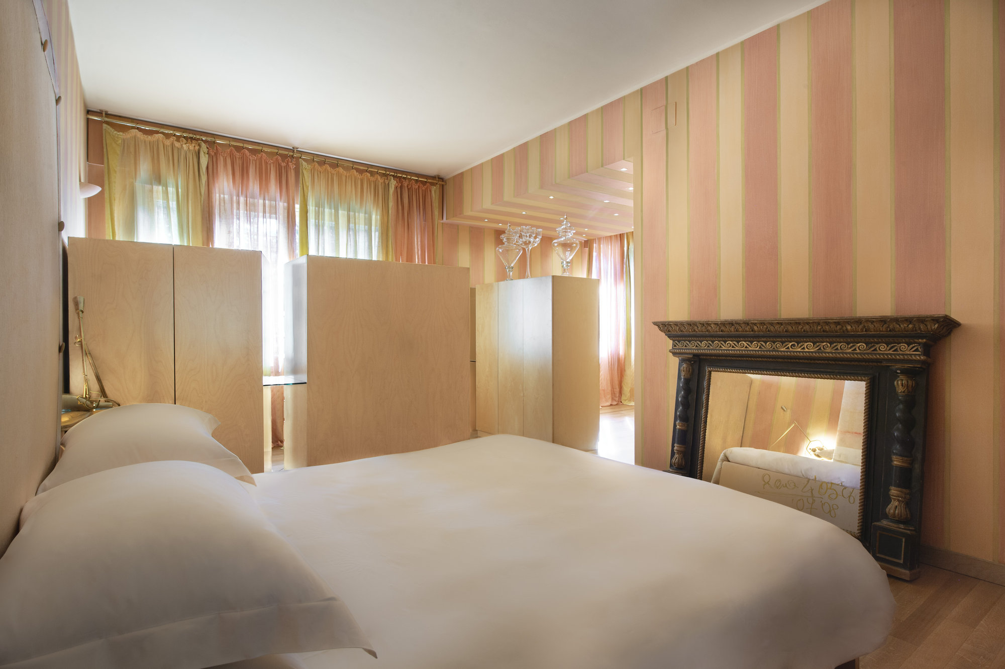 Bedroom with striped walls and antique mirror
